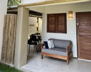 a couch sitting on the porch of a house at Condomínio Praias de Maragogi & Casas Deluxe in Maragogi