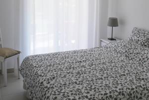 a bedroom with a black and white bed and a window at Colore di Mare in Cavalaire-sur-Mer