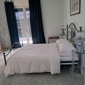 Un dormitorio con una cama blanca y una mesa de cristal. en B&B La Magnolia, en Arena Po
