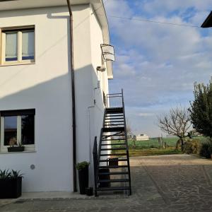una scala che porta a un edificio bianco di B&B La Magnolia a Arena Po