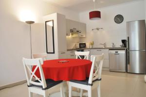 a kitchen with a red table and white chairs at Colore di Mare in Cavalaire-sur-Mer