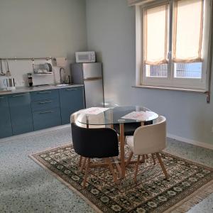 cocina con mesa de cristal y 2 sillas en B&B La Magnolia, en Arena Po