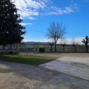 Un parque con un edificio, un árbol y una valla. en B&B La Magnolia, en Arena Po
