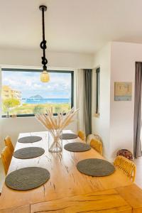 een eettafel met stoelen en een groot raam bij Interni Villa by A&D Properties in Porto Rafti