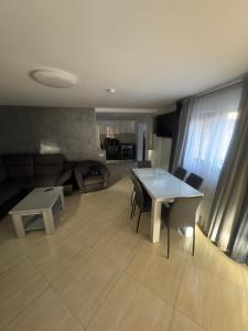 a living room with a table and a couch at Casa Sophia Maria Caciulata in Caciulata