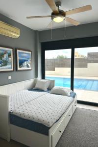 een slaapkamer met een bed met een plafondventilator bij Interni Villa by A&D Properties in Porto Rafti
