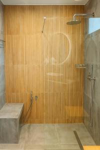 een badkamer met een douche en een bank. bij Interni Villa by A&D Properties in Porto Rafti +16 foto's