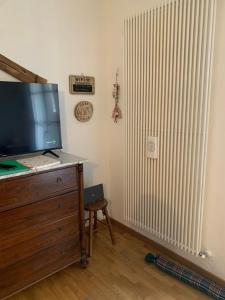 a room with a television on a dresser and a radiator at Casa Dalja in Abetone +57 photos