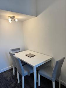 a white table with two chairs and a book on it at Holgate Cottage in Great Harwood +2 photos