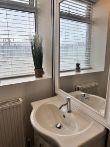 a bathroom with a sink and a mirror at Holgate Cottage in Great Harwood