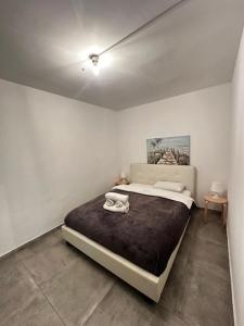 una camera da letto con un letto grande in una stanza bianca di ARSENIa COTTAGE a Kyperounda