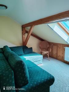 een woonkamer met een groene bank en een raam bij Erdőalja-Padlástér in Jásd