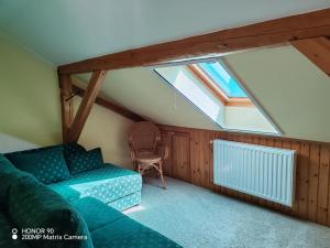 een woonkamer met een bank en een raam bij Erdőalja-Padlástér in Jásd