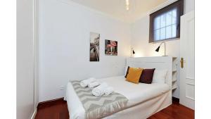 Un dormitorio con una cama blanca con toallas. en Comfy 1 BR Flat - Bright, Central & Calm, en Madrid