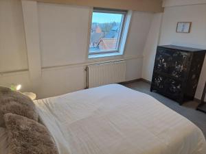 ein Schlafzimmer mit einem großen weißen Bett und einem Fenster in der Unterkunft De Peperbus in Lokeren