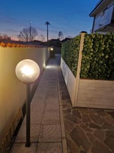 a street light next to a wall with a hedge at La Petite Maison in Fiumicino +14 photos