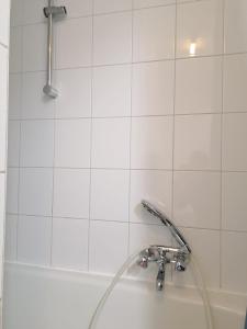 eine Badewanne mit Duschkopf und Waschbecken in der Unterkunft De Peperbus in Lokeren