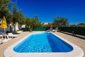 a swimming pool with blue water in a backyard at Holiday House Olive in Solin