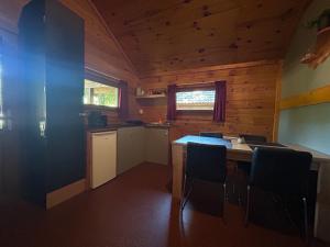 a kitchen with a table and chairs in a cabin at Vakantiepark Zwartemeer in Zwartemeer +6 photos