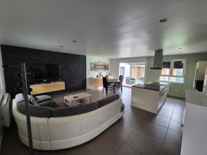 un ampio soggiorno con divano e cucina di Chez Roberto a La Chapelle-Saint-Mesmin