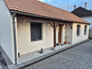 un gatto seduto su un marciapiede accanto a una casa di Chez Roberto a La Chapelle-Saint-Mesmin