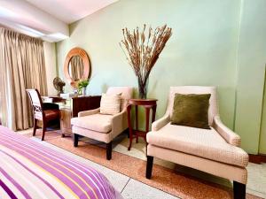 a bedroom with two chairs and a desk and a mirror at WiNNiNE Cozy Home in Bangkok +114 photos