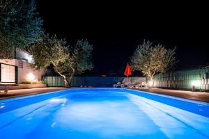 a swimming pool at night with lights on at Holiday House Olive in Solin +42 photos
