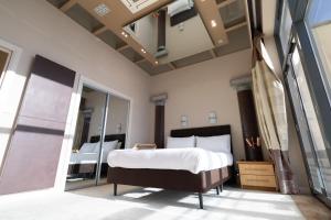 a bedroom with a large bed and a mirror at Stunning Swansea Marina beach house with sea views in Swansea