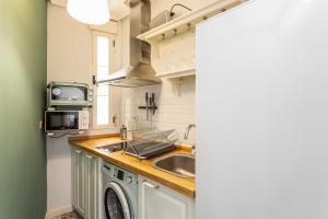 una cocina con fregadero y lavadora en Cozy 1BD Apartment in Alonso Martínez, en Madrid 14 fotos más