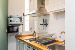 una cocina con fregadero y microondas en Cozy 1BD Apartment in Alonso Martínez, en Madrid