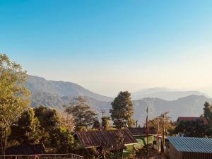 a view of a village with mountains in the background at Cinchonna Farmstay in Darjeeling