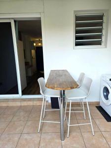 圣丹尼斯Sawadee Studio, meublé & jardin的一张桌子、两把椅子和一台洗衣机