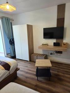 圣丹尼斯Sawadee Studio, meublé & jardin的一间卧室，里面有一张床和一台平板电视