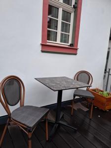 a table and two chairs and a table and a window at Gästehaus Grüner Baum in Oestrich-Winkel