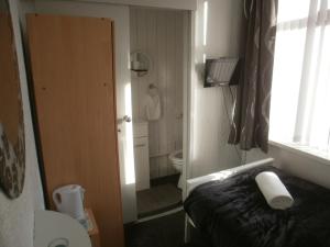 een kleine badkamer met een bed en een toilet bij Marsden B&B in Blackpool +2 foto's