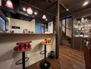 a bar with two stools in front of a counter at 浪漫宿花町 in Mitarai