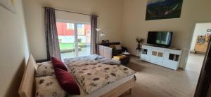 un soggiorno con un divano e una televisione di Gästehaus Hähnchenbach a Kelberg Altre 15 foto