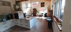 una cucina con armadi bianchi e una sala da pranzo di Gästehaus Hähnchenbach a Kelberg