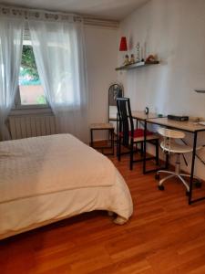 ein Schlafzimmer mit einem Bett, einem Schreibtisch und einem Tisch in der Unterkunft Dauriac 256 in Guilherand