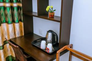 a tea kettle on a table in a room at Sanda Hiru Guest in Mirissa