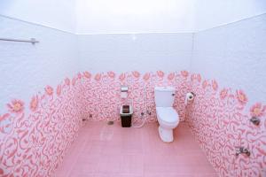 a bathroom with a toilet with pink flowers on the wall at Sanda Hiru Guest in Mirissa +58 photos