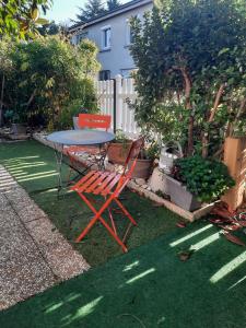 a table and chairs sitting in a yard at Voie bleue Bords du Rhône in Guilherand