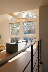 a living room with a couch and two windows at Peak Hakuba 峰白 in Nagano