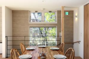a dining room with a wooden table and chairs at Peak Hakuba 峰白 in Nagano