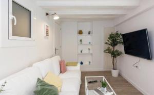 un salon blanc avec un canapé blanc et une télévision dans l'établissement Ramblas Apartment Central BCN, à Barcelone