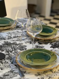 dos copas de vino y platos en una mesa en Casa do Juiz, en Barca da Amieira