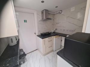 a small kitchen with a stove and a refrigerator at 2 bedroom Flat Heathrow in Feltham