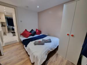 a bedroom with a bed with two pillows on it at 2 bedroom Flat Heathrow in Feltham