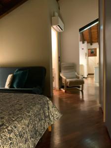 a bedroom with a bed and a couch and a chair at Ca' Molinetto in Treviso