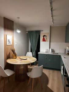 a kitchen with a table and chairs in a room at Mieszkanie w centrum miasta in Kętrzyn